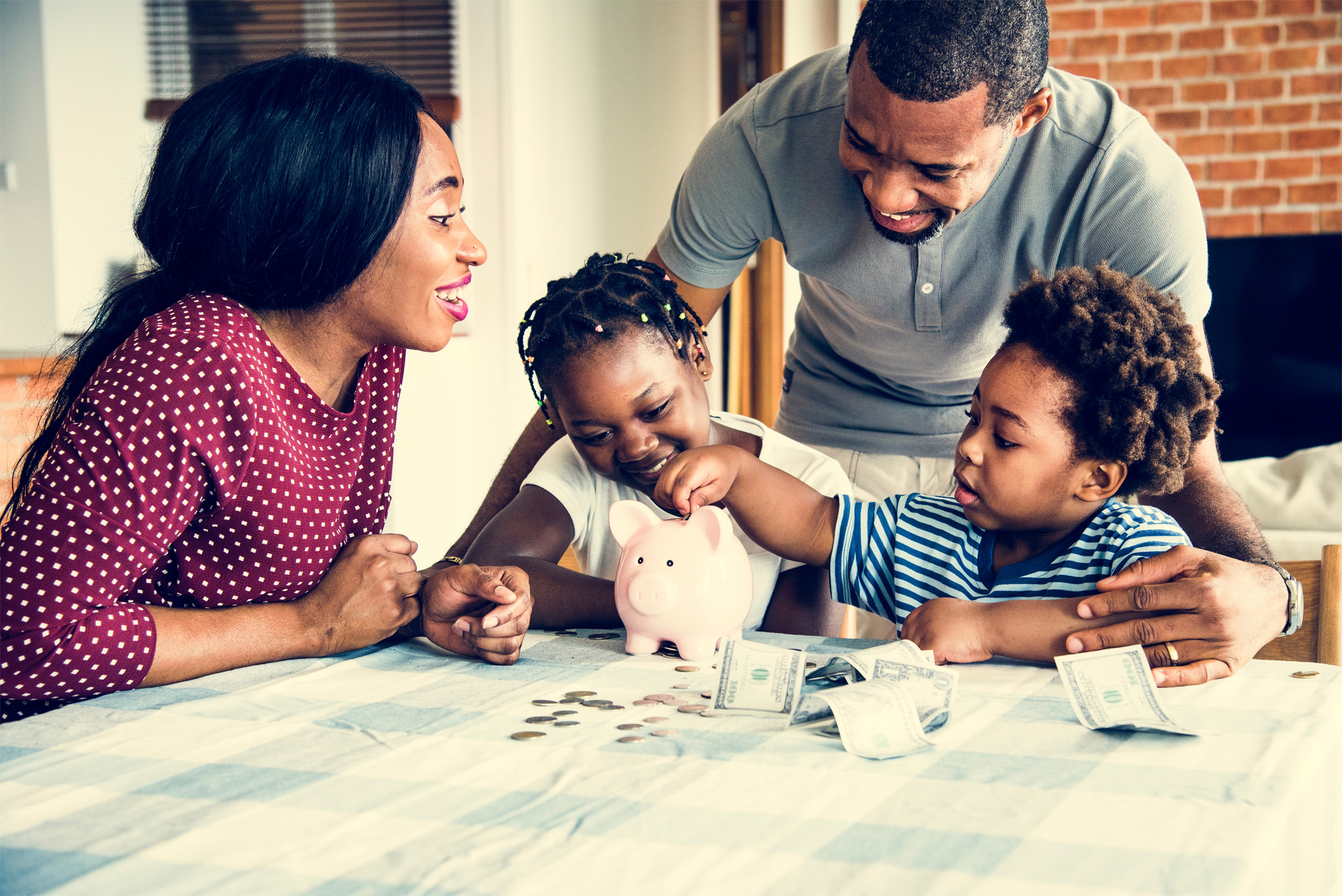 Family enjoying money savings being placed into a piggy bank