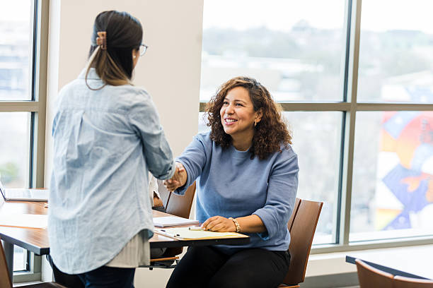 Smiling women shaking hands in a business meeting. Casual, friendly atmosphere.