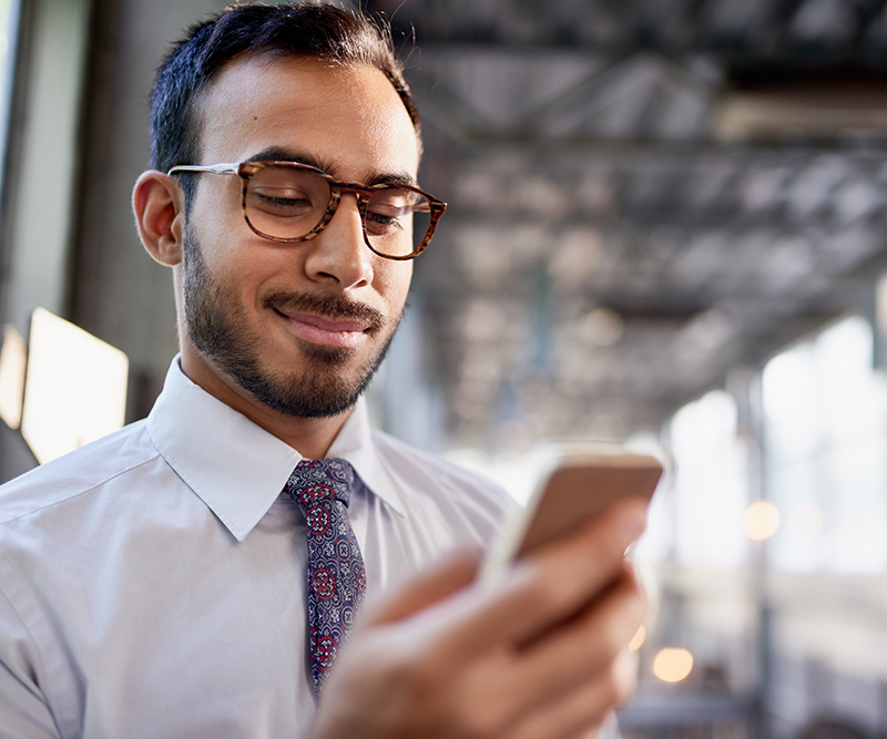 Portrait of a confident, happy business entrepreneur wearing fashionable tie and eyewear on his way to his next consultant meeting on the train platform